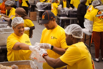 Dr. Mitchell, Secretary Monteiro pack food with Terps Against Hunger at Langley Park Community Center